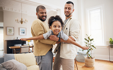 Image showing Happy family, gay parents and girl flying in home or playing, holding kid as a plane, lifting or bonding in fun living room game. LGBT, father and dad support child together in the air or lounge