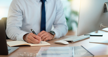 Image showing Lawyer and attorney working on corporate plans and compiling legal reports for a case at his desk. Business man and project manager writing notes on paper while working on a computer in an office