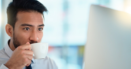 Image showing Focused lawyer sipping a cappuccino while working on a case for his upcoming legal trial. Closeup of the face and head of a young male advocate researching the law on his computer while preparing