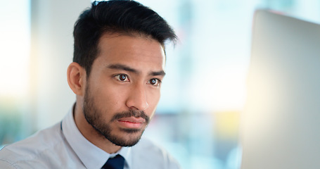 Image showing Business man reading his emails and browsing online on a desktop computer while working in an office at work. One male corporate worker while networking and connecting with clients on the internet