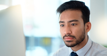 Image showing Business man reading his emails and browsing online on a desktop computer while working in an office at work. One male corporate worker while networking and connecting with clients on the internet