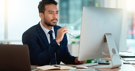 Image showing Business man analyzing a project strategy on a computer screen while working in an office. Serious and focused corporate professional thinking of solutions while considering ideas, choices and plans