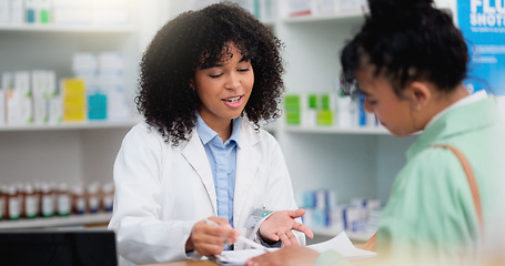 Image showing Pharmacist helping a customer in a pharmacy. Woman signing medical paperwork to collect over the counter and prescription medication from a friendly healthcare worker in a chemist or dispensary