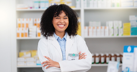 Image showing Portrait of a pharmacist with folded arms against a background of prescription medication. Happy young professional health care worker waiting to diagnose and prescribe pills at a clinic dispensary