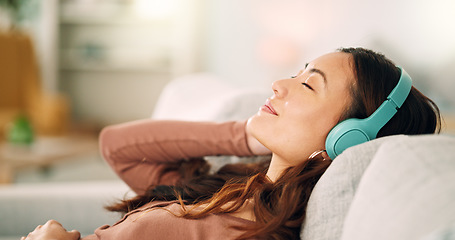 Image showing Woman headphones, listening to relax music, podcast and smile with a calm, zen and peaceful day at home. Happy Asian female and relaxed woman sitting on a living room sofa and meditation with audio