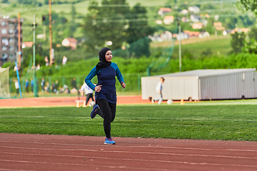 Image showing A muslim woman in a burqa sports muslim clothes running on a marathon course and preparing for upcoming competitions