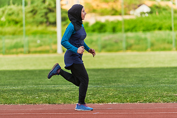 Image showing A muslim woman in a burqa sports muslim clothes running on a marathon course and preparing for upcoming competitions