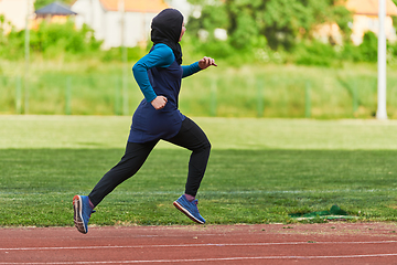 Image showing A muslim woman in a burqa sports muslim clothes running on a marathon course and preparing for upcoming competitions