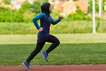 Image showing A muslim woman in a burqa sports muslim clothes running on a marathon course and preparing for upcoming competitions