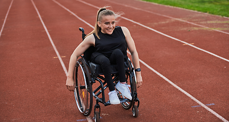 Image showing A woman with disablity driving a wheelchair on a track while preparing for the Paralympic Games