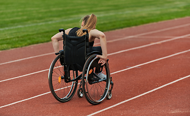Image showing A woman with disablity driving a wheelchair on a track while preparing for the Paralympic Games