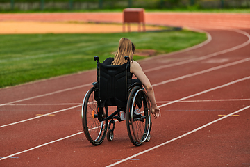 Image showing A woman with disablity driving a wheelchair on a track while preparing for the Paralympic Games