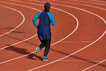 Image showing A muslim woman in a burqa sports muslim clothes running on a marathon course and preparing for upcoming competitions