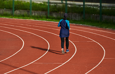 Image showing A muslim woman in a burqa sports muslim clothes running on a marathon course and preparing for upcoming competitions