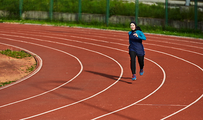 Image showing A muslim woman in a burqa sports muslim clothes running on a marathon course and preparing for upcoming competitions