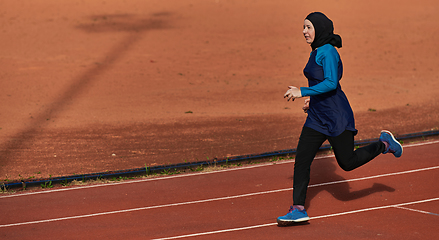 Image showing A muslim woman in a burqa sports muslim clothes running on a marathon course and preparing for upcoming competitions