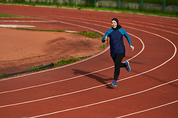 Image showing A muslim woman in a burqa sports muslim clothes running on a marathon course and preparing for upcoming competitions