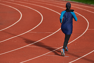 Image showing A muslim woman in a burqa sports muslim clothes running on a marathon course and preparing for upcoming competitions