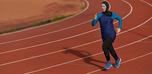 Image showing A muslim woman in a burqa sports muslim clothes running on a marathon course and preparing for upcoming competitions