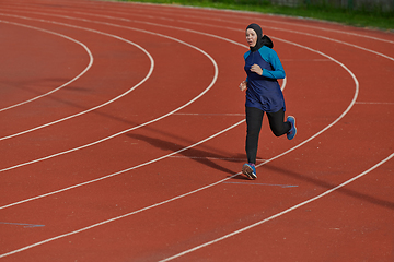 Image showing A muslim woman in a burqa sports muslim clothes running on a marathon course and preparing for upcoming competitions