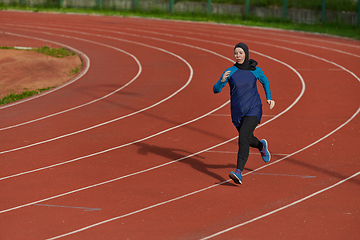 Image showing A muslim woman in a burqa sports muslim clothes running on a marathon course and preparing for upcoming competitions