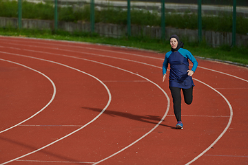 Image showing A muslim woman in a burqa sports muslim clothes running on a marathon course and preparing for upcoming competitions