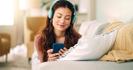 Image showing Relax, music and phone with woman in living room and headphones listening to radio, podcast or podcast. Happy, freedom and internet with girl on sofa, streaming for audio, social media or online