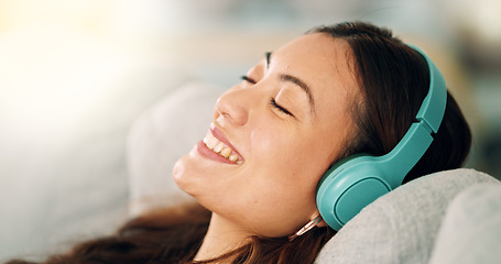 Image showing Relax, headphones and happy woman listening to music, radio or podcast while resting on sofa. Happiness, smile and calm girl from singapore sitting on the couch in living room at home with technology