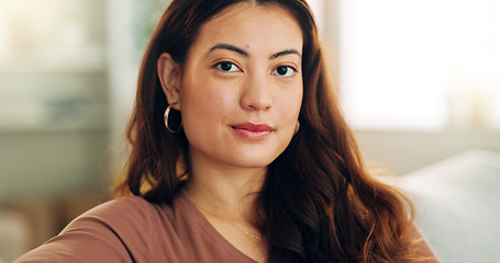 Image showing Serious woman, relax and home with a beautiful asian female feeling calm, peaceful and enjoying her free time on the sofa at home. Portrait and face of a young female sitting in her singapore house