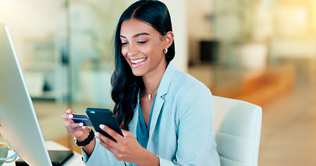 Image showing Happy woman making online payment with phone and bank card for typing credit details into online banking app. Young business woman enjoying virtual shopping or wireless purchase while sitting inside