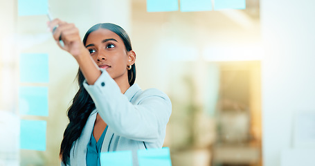 Image showing A smart female entrepreneur planning the strategy of her company in the office. Young confident and successful business woman leader thinking and working on a project at the workplace