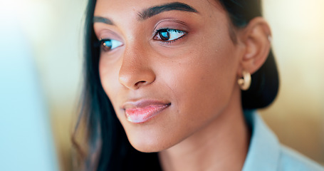 Image showing Business woman reading information on a computer screen while working in an office. Closeup on face of one confident young entrepreneur and focused expert carefully analyzing ideas and plans online