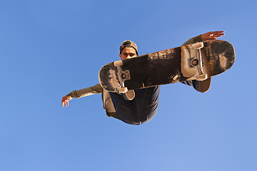 Image showing Have you see the skills on this one. A young man doing tricks on his skateboard at the skate park.