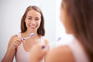 Image showing Taking care of her smile. A young woman brushing her teeth.