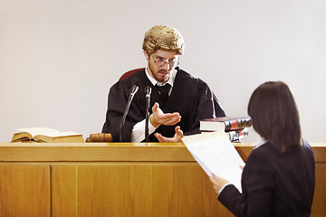 Image showing Present your case.... Serious young judge sitting in the courtroom with a stern facial expression.