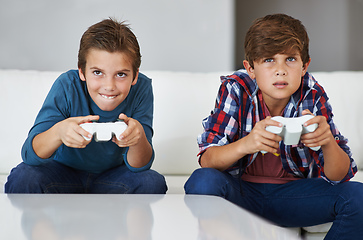 Image showing Im gonna beat you. Shot of two young boys concentrating while playing video games.