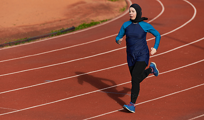 Image showing A muslim woman in a burqa sports muslim clothes running on a marathon course and preparing for upcoming competitions