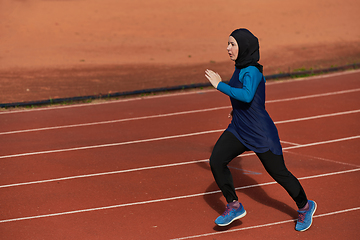 Image showing A muslim woman in a burqa sports muslim clothes running on a marathon course and preparing for upcoming competitions