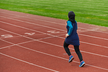 Image showing A muslim woman in a burqa sports muslim clothes running on a marathon course and preparing for upcoming competitions