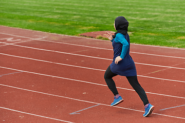 Image showing A muslim woman in a burqa sports muslim clothes running on a marathon course and preparing for upcoming competitions