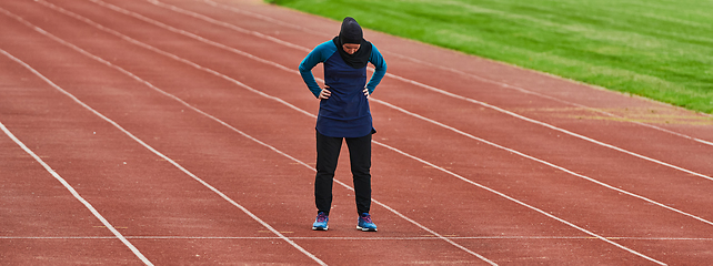 Image showing A muslim woman in a burqa sports muslim clothes running on a marathon course and preparing for upcoming competitions