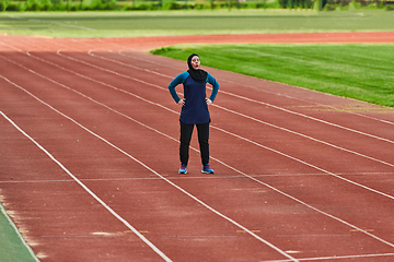 Image showing A muslim woman in a burqa sports muslim clothes running on a marathon course and preparing for upcoming competitions