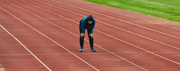 Image showing A muslim woman in a burqa sports muslim clothes running on a marathon course and preparing for upcoming competitions