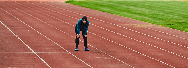 Image showing A muslim woman in a burqa sports muslim clothes running on a marathon course and preparing for upcoming competitions