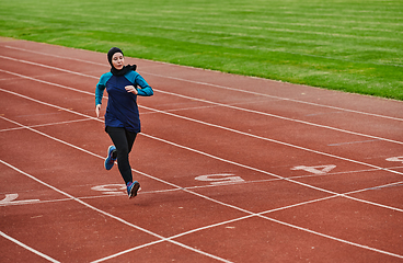 Image showing A muslim woman in a burqa sports muslim clothes running on a marathon course and preparing for upcoming competitions