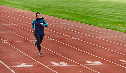 Image showing A muslim woman in a burqa sports muslim clothes running on a marathon course and preparing for upcoming competitions