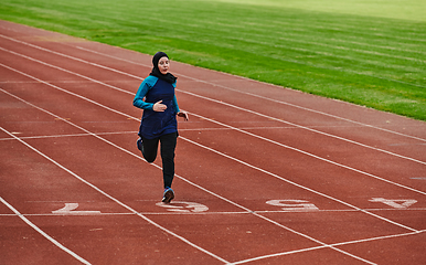 Image showing A muslim woman in a burqa sports muslim clothes running on a marathon course and preparing for upcoming competitions