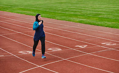 Image showing A muslim woman in a burqa sports muslim clothes running on a marathon course and preparing for upcoming competitions