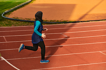 Image showing A muslim woman in a burqa sports muslim clothes running on a marathon course and preparing for upcoming competitions