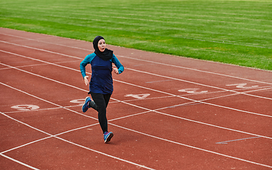 Image showing A muslim woman in a burqa sports muslim clothes running on a marathon course and preparing for upcoming competitions